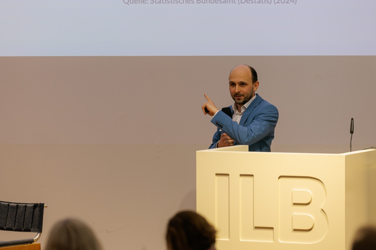 Bild: Während seines Vortrags zeigt Roman Wink, Senior Project Manager der Bertelsmann Stiftung, auf die Präsentation. 