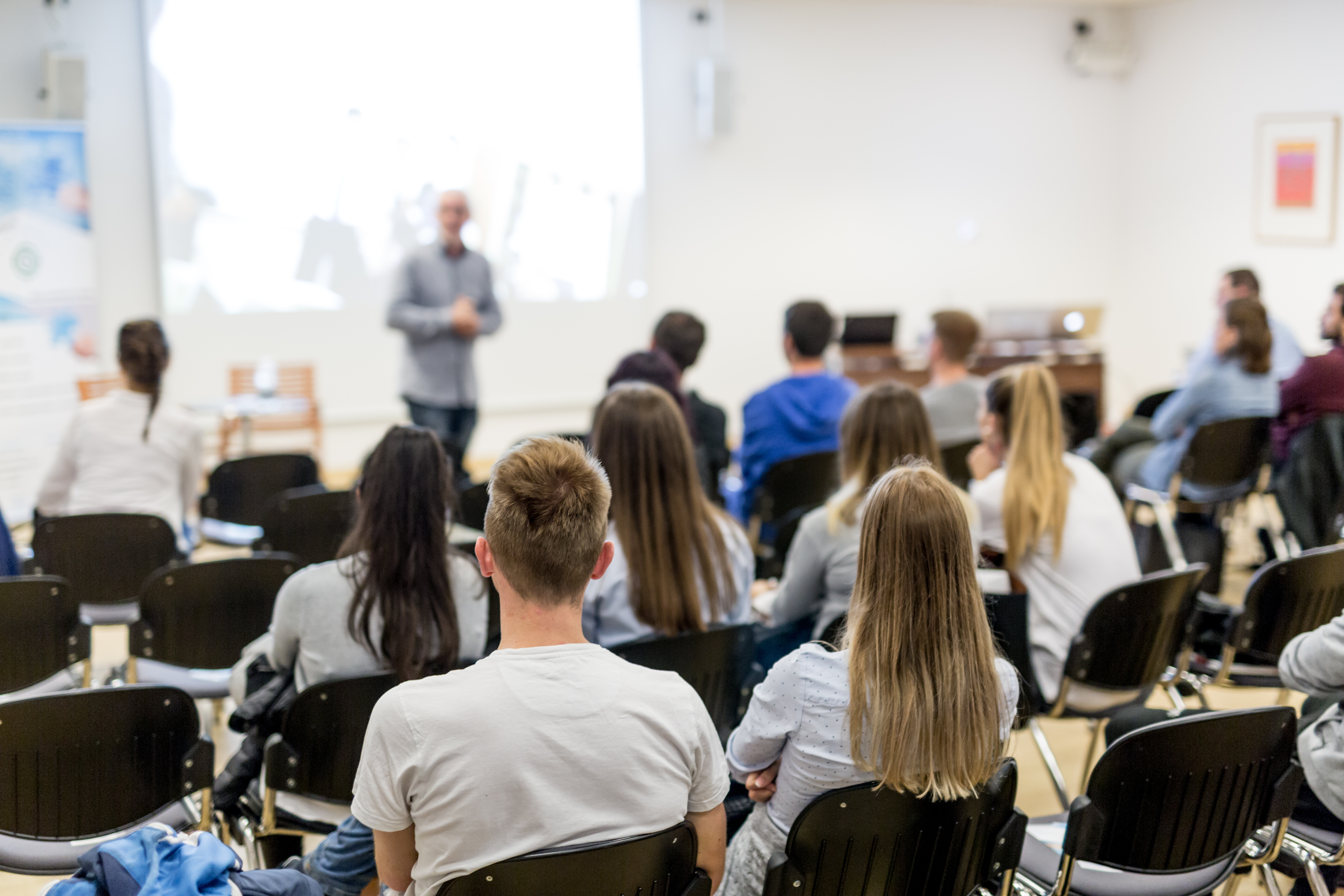 Schülerinnen und Schüler hören einem Vortrag zu