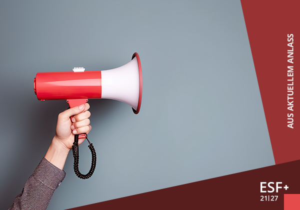 Hand am linken Bildrand hält ein Megafon, das von der Seite zu sehen ist.