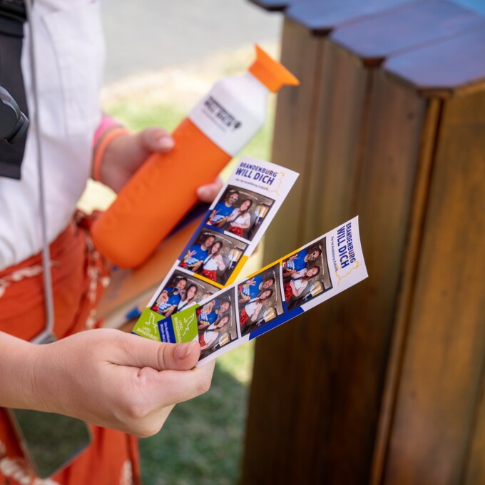 Nahaufnahme einer Hand, die mehrere Fotostreifen hält.