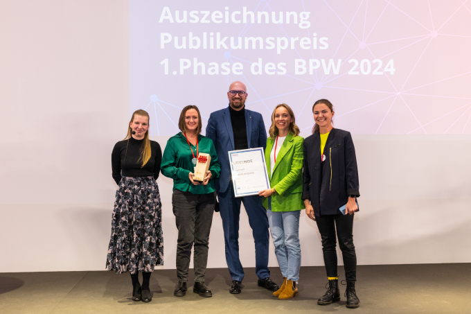 Gruppenbild mit Moderatorin Janine Korbaniak (links), dem Gründerinnen-Team von PlayTravel und Staatssekretär Michael Biel.