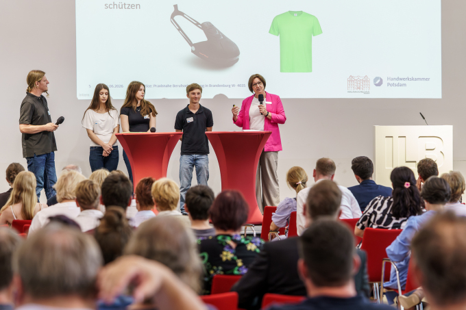 Es stehen merhere beteilgte des Projekts Praxislernen in Werkstätten auf der Bühne und halten eine Präsentation