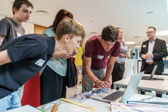 Merhere Schüler probieren sich an einem Messestand aus